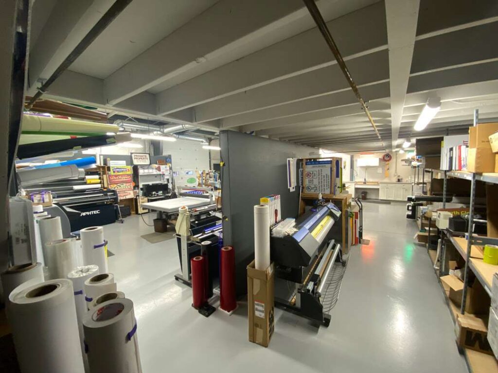 Large-format print shop with worktables and equipment.